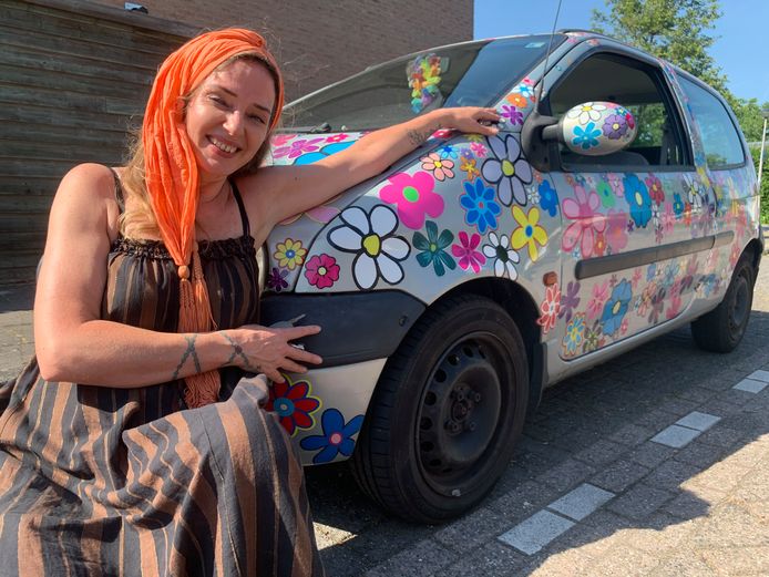 Cindy van Kuyen poseert met haar auto ‘Maria’, die elke keer als ze door de keuring komt een 'bos bloemen' krijgt opgeplakt. Het is daardoor een vrolijke wagen geworden.