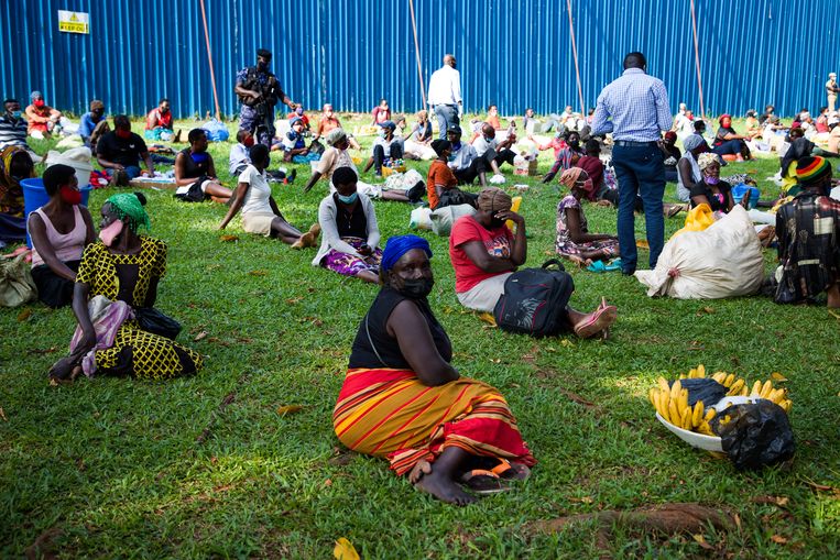Op een veld in Kampala zitten allemaal verkopers die door de politie zijn aangehouden. Beeld Katumba Badru