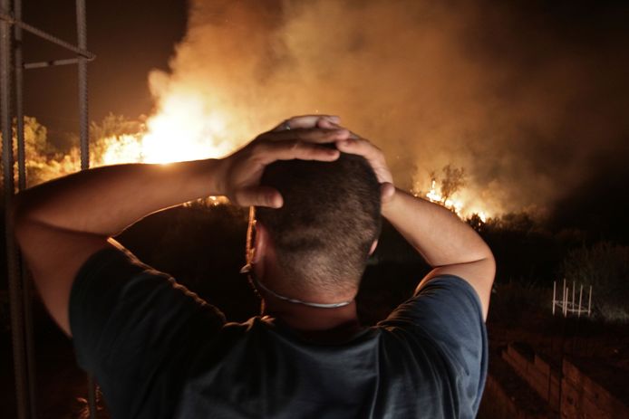 Een man in Larbaa Nath Irathen kijkt op 11 augustus naar de branden die het dorp teisteren, op de dag dat Djamel Bensmaïl arriveerde.