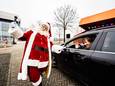 Zorgmedewerkers van de Drie Gasthuizen Groep krijgen hun kerstpakket in een drive-through bij Gelredome. De kerstman is ook van de partij: ,,Ho ho hooo!"