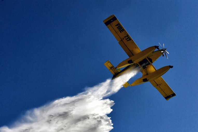 Een blusvliegtuig laat water vallen om de brand te blussen in het dorp Agios Ioannis, Korinthe, Griekenland. Ook Griekenland heeft te maken met bosbranden op verschillende plaatsen in het land.  Beeld ANP / EPA
