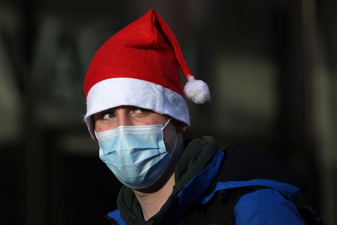 Een man met een kerstmuts en een mondmasker op in Londen.