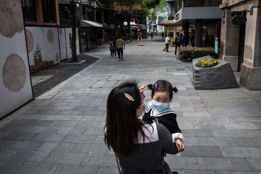 Een mama met haar dochter in Wuhan. Twee van de Amerikaanse functionarissen stellen dat het rapport concludeert dat de cijfers van China nep zijn. 