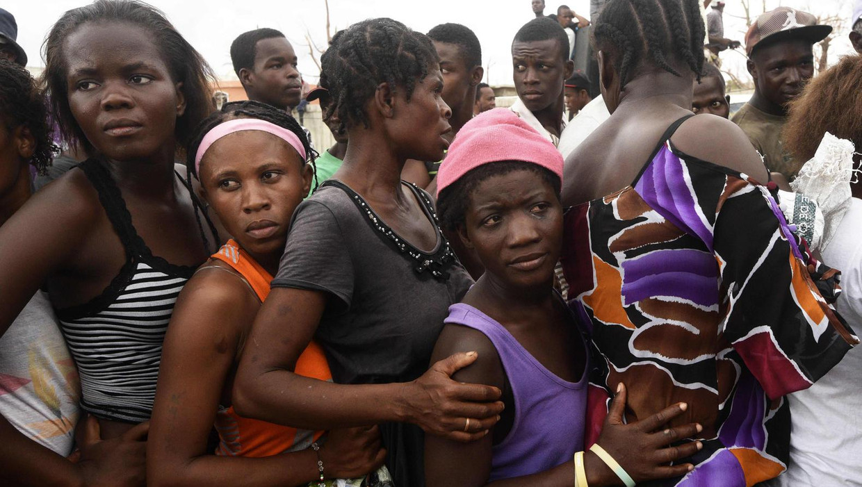 Mensen staan in de rij voor voedsel en kleding die worden uitgedeeld in een opvangkamp op Haïti. Beeld afp