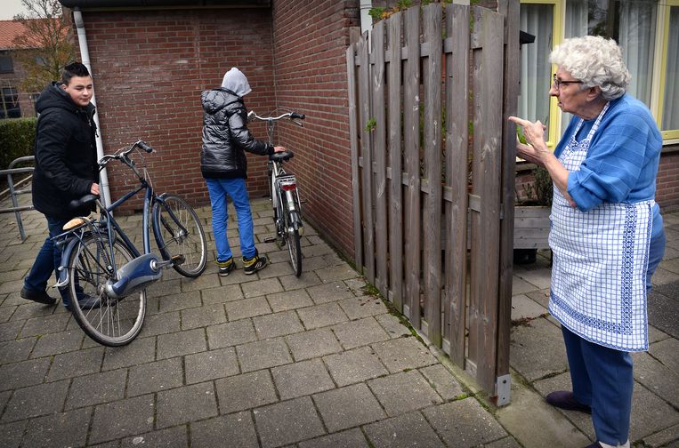 Een oudere vrouw vraagt enkele hangjongeren ergens anders te gaan hangen, maar niet bij haar huis. Beeld Marcel van den Bergh / de Volkskrant
