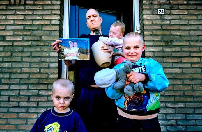 Ricardo Legen met hun drie kinderen Jailey (1), Damon (3) en Lucas (7). In zijn handen een trouwfoto en de urn met de as van zijn overleden vrouw Hennie.