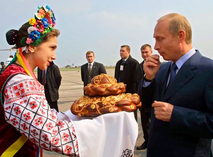 Een vrouw in Oekraïnse klederdracht verwelkomt de Russische president, tijdens een bezoek in 2002.