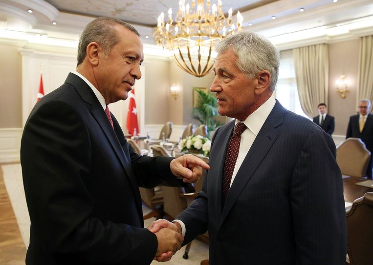 De Turkse president Erdogan (links) schudt de hand van de Amerikaanse minister van Defensie, Chuck Hagel. Beeld afp