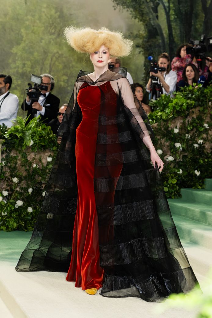 Gwendoline Christie viel op met haar bijzondere haarstijl en rood-zwarte jurk.