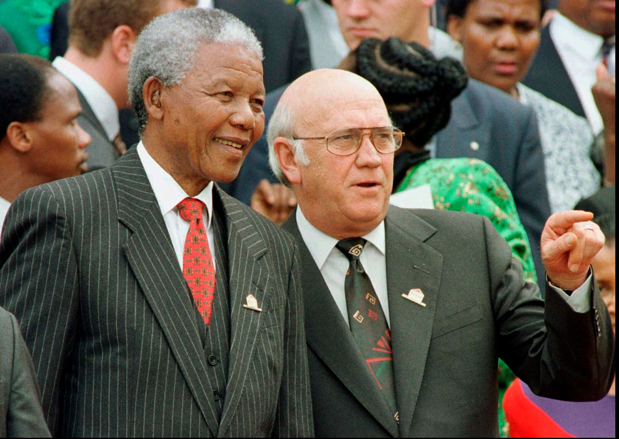 F.W. de Klerk en Nelson Mandela in 1996 bij de goedkeuring van de nieuwe, democratische grondwet door het parlement in Kaapstad. De Klerk was op dat moment vicepresident, Mandela was president.