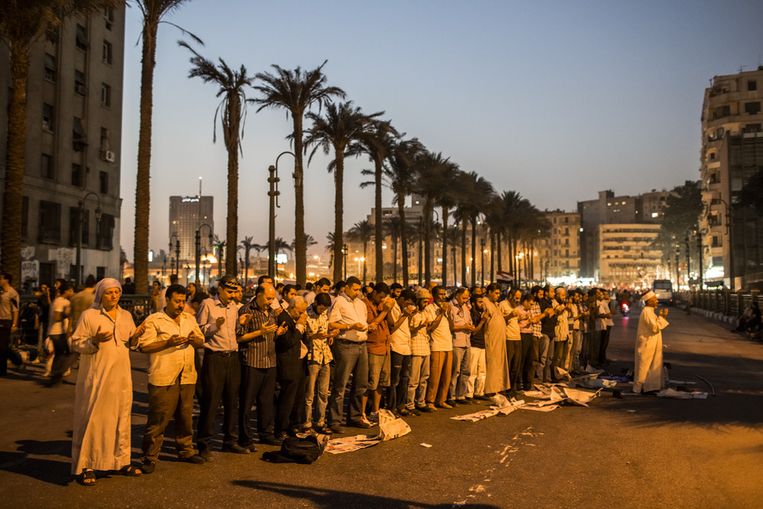 Aanhangers van de Moslimbroeders bidden voor hun kandidaat Morsi op straat in Caïro. Beeld getty