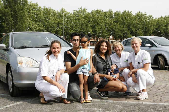 Verlos- en verpleegkundigen op het parkeerterrein Hagaziekenhuis samen met Naomi Kroon en Kevin White, dochter Evina en pasgeboren zoontje Marcellus.