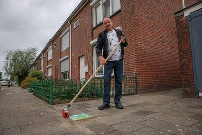 Buurtbezem en siertegel voor Helwijker, die stoep en brandgang onkruidvrij houdt