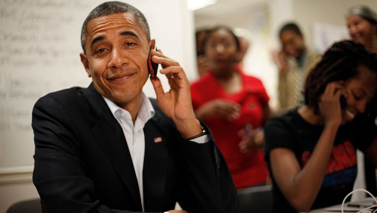 Barack Obama realiseert zich dat hij een verkeerd nummer heeft gedraaid tijdens een actie op een van zijn campagnekantoren. Beeld AP
