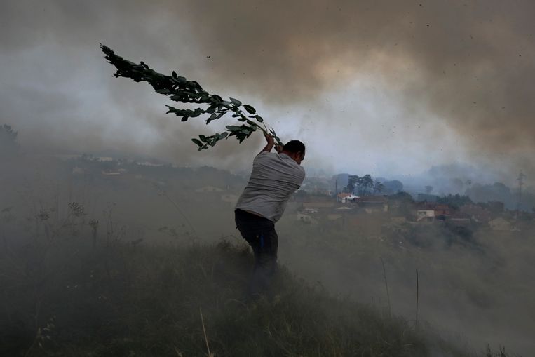 Een vrijwilliger probeert te voorkomen dat een bosbrand huizen bereikt in het dorp Casal da Quinta, buiten Leiria, midden Portugal.  Beeld AP