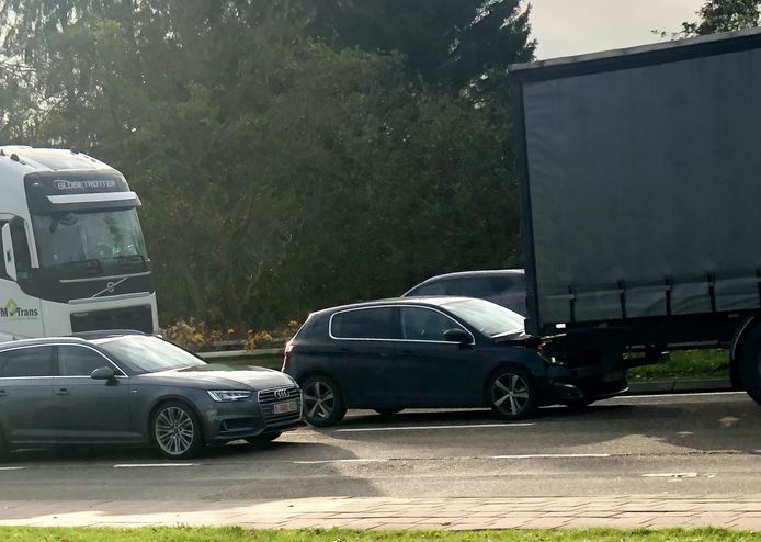 De Peugeot van de vrouw werd door de witte truck onder de andere vrachtwagen geduwd.