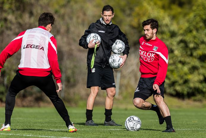 Jordy Bruijn aan de bal tijdens een van de laatste trainingen van NEC in Zuid-Spanje. Trainer Rogier Meijer kijkt toe.