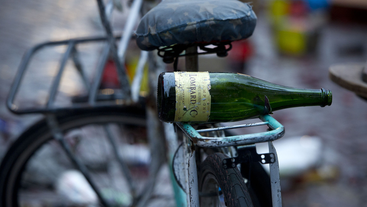 Lege fles achterop een bagagedrager. Beeld anp