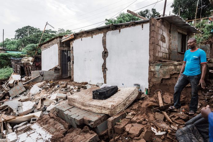 Jason Mthembu staat naast de resten van zijn huis dat door de overstromingen en hevige regenval vernietigt werd.