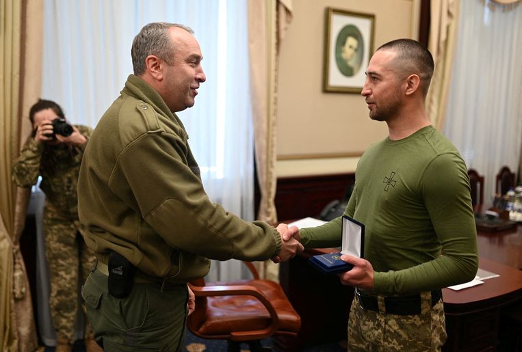 De Oekraïense soldaat Roman Hrybov (rechts) heeft een medaille gekregen voor zijn dappere verzet tegen Rusland.  Beeld REUTERS