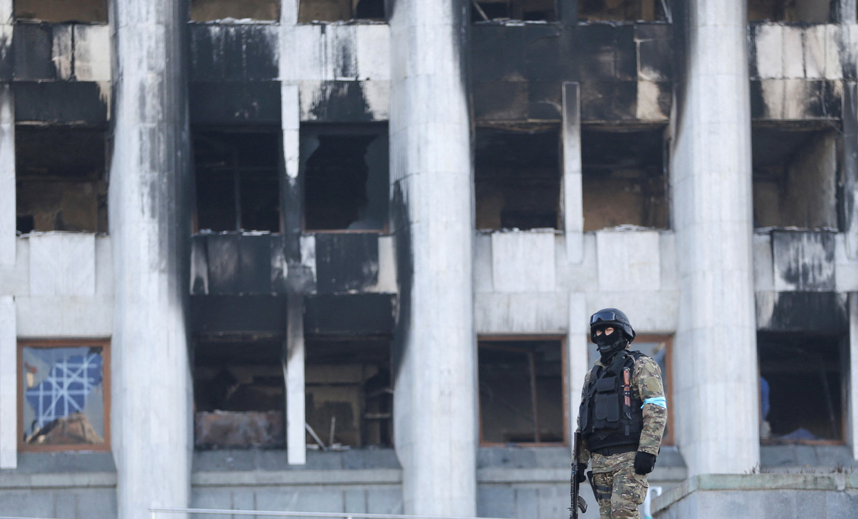 Een Kazachse militair houdt de wacht bij het stadhuis van Almaty dat tijdens de recente protesten in brand werd gestoken. Beeld REUTERS