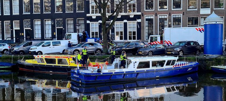 Boten van de politie schermen de plek af waar het lijk is aangetroffen. Beeld Het Parool
