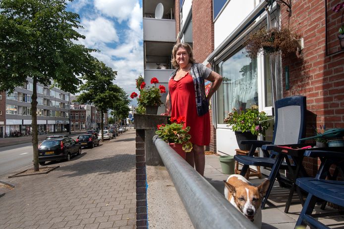 Hanny Hessing met hondje Djeny op haar balkon aan de Van Muijlwijkstraat in Arnhem. ,,Hier is altijd wat te zien.”