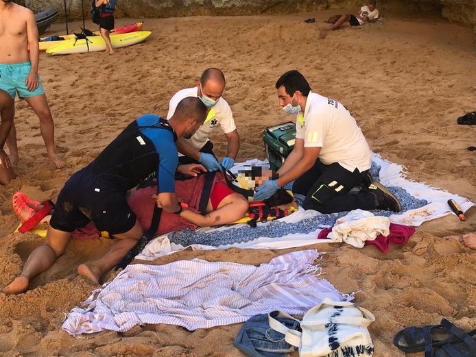 Hulpverleners bekommeren zich om het slachtoffer op het strand in Albufeira.