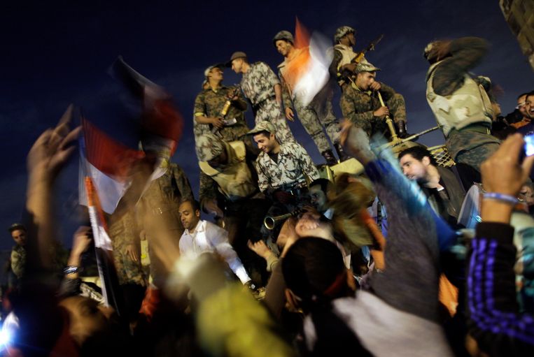 Egyptische burgers en militairen feesten op het Tahrirplein na de afzetting van dictator Hosni Mubarak, op 25 januari 2011. Beeld EPA