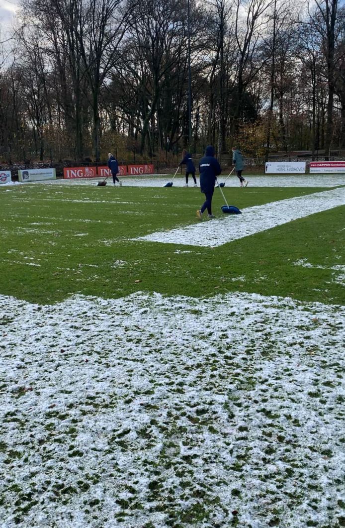 Speelsters van FC Eindhoven Vrouwen zorgen ervoor dat het veld speelklaar is.