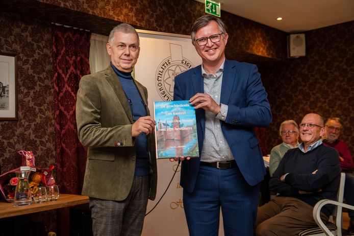 Auteur Maarten Bicknese  overhandigt wethouder Ger de Weert het eerste exemplaar.