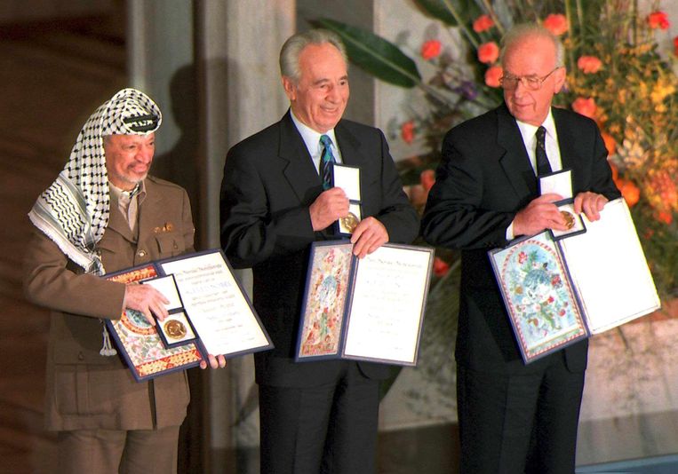 De Palestijnse leider Yasser Arafat (links), Shimon Peres (midden) en toenmalig premier Yitzhak Rabin (rechts) met hun Nobelprijs. Beeld EPA