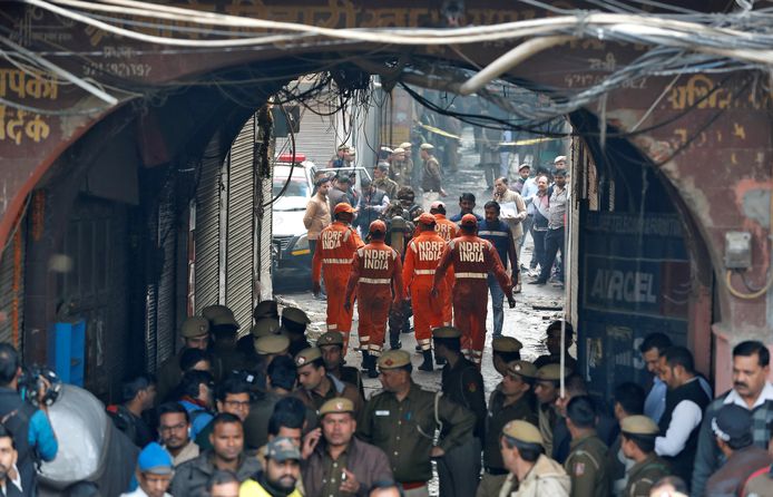 Ambulances zijn ter plekke terwijl politie en brandweer aan het werk zijn bij een brand in fabriek in New Delhi, waarbij tenminste 40 arbeiders omkwamen.