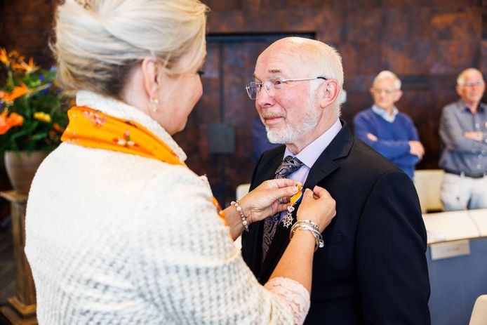 Henk van den Hoven krijgt een koninklijke onderscheiding opgespeld door burgemeester Sacha Ausems.