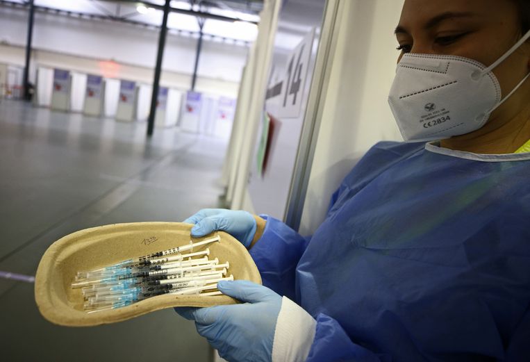 Een arts met een aantal injectiespuiten die een dosis van het AstraZeneca-vaccin bevatten. Beeld Reuters
