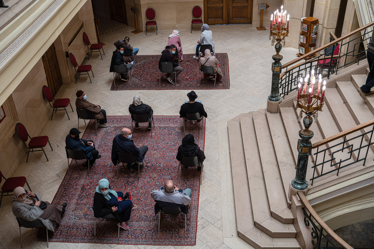 Mensen wachten op een prik in het gemeentehuis.  Beeld Wouter Van Vooren