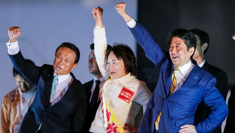De Japanse premier Shinzo Abe (R), minister van Financiën Taro Aso (L) en een kandidaat van Abes Liberaal Democratische Partij (LDP) bij de laatste campagnebijeenkomst. Beeld epa