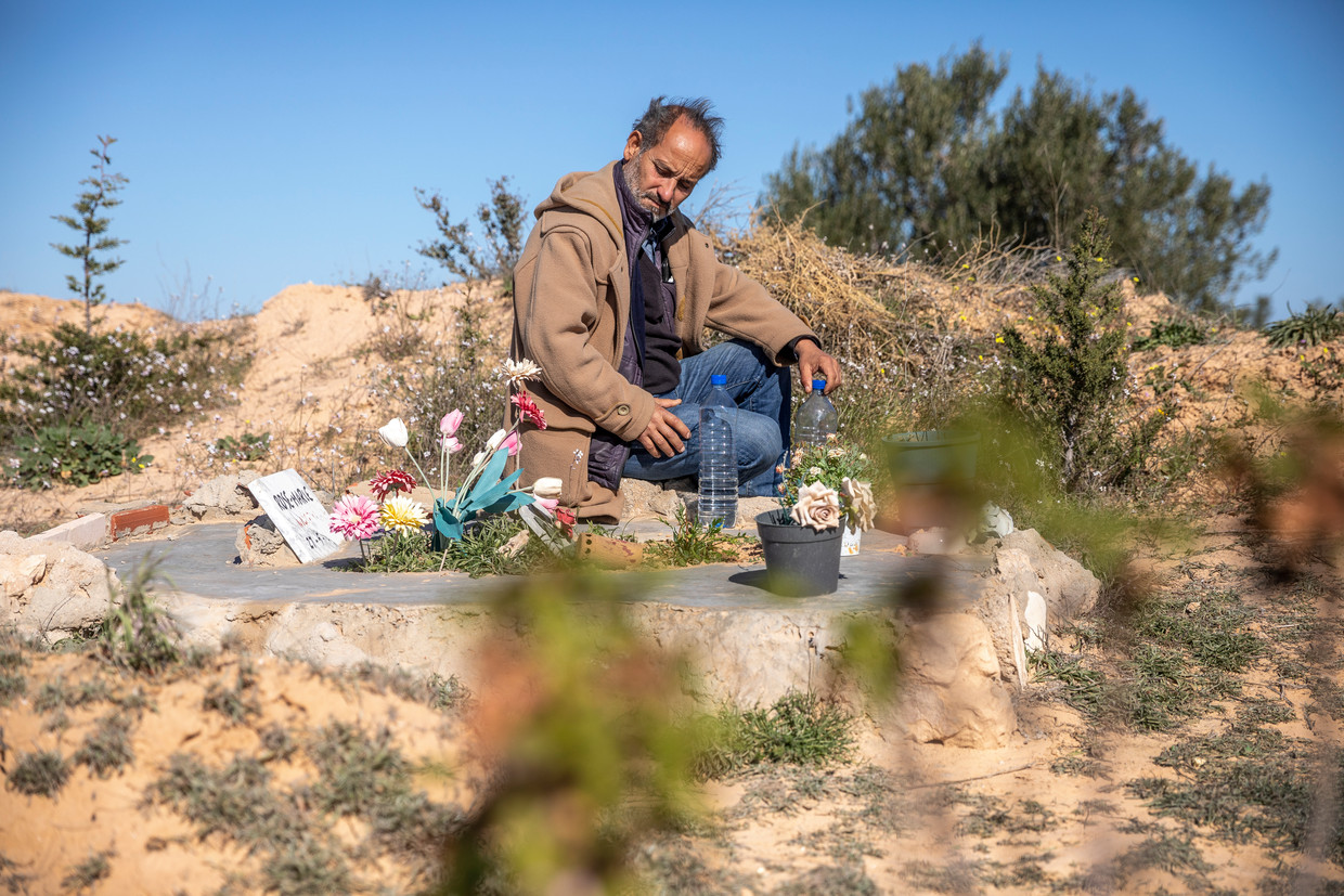 Chamseddine Marzoug zit bij een van de ruim vierhonderd graven voor verdronken migranten in Zarzis. Beeld Sven Torfinn / de Volkskrant