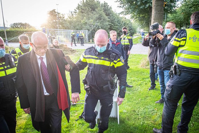 Actievoerder Martin Mourik wordt door de politie meegenomen en afgevoerd.