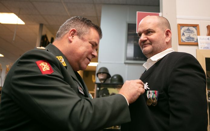 Kolonel Ludy de Vos, directeur van het Veteranen Instituut in Doorn, speldt het DIG op de revers van Michel Noppers.