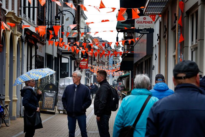 Jos van Eijndhoven (midden) en zijn vrouw Ien (links) uit Liempde bezochten maandagmiddag Gorinchem. Ze zijn in gesprek op de Langendijk, terwijl op de voorgrond ander toeristen wandelen.