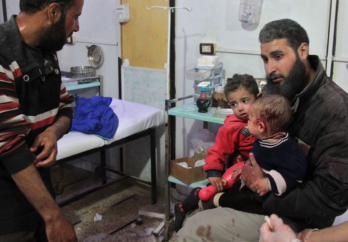 Een man met twee gewonde kinderen in een veldhospitaal na een luchtaanval door het Syrische regeringsleger in Ghouta.