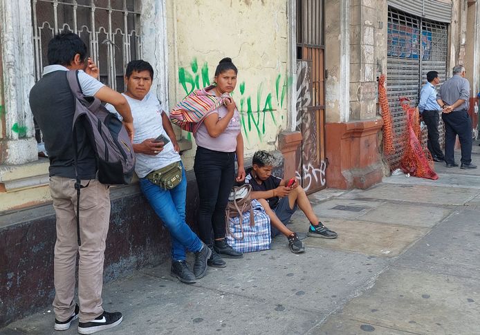 Familieleden van de gearresteerde demonstranten wachten op informatie bij een politiebureau in Lima.
