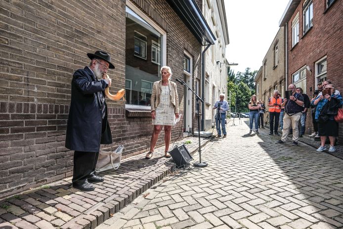 Rabbijn Izak Vorst blaast op de sjofar tijdens het plaatsen van een struikelsteen in de Hamelstraat in Terborg.