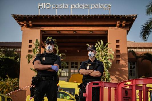 Agenten met mondkapjes op houden de wacht voor het hotel in Adeje op Tenerife.