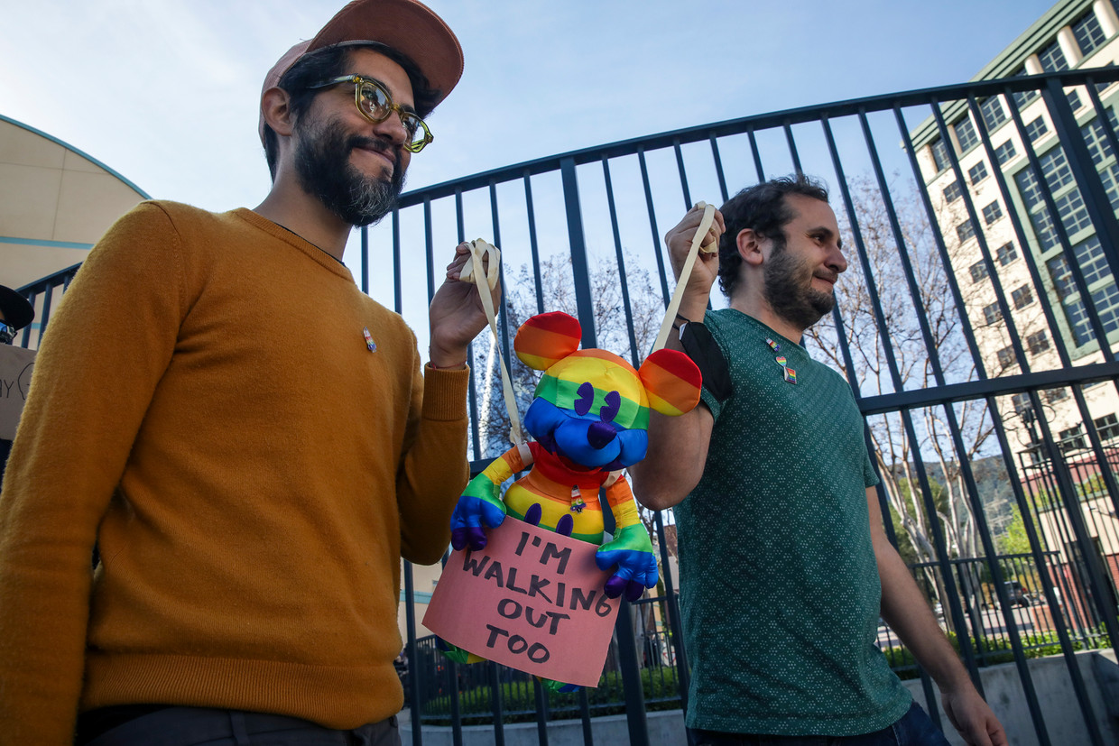 Medewerkers van Disney lopen met een Mickey Mouse in regenboogkleuren. Ze protesteerden tegen hun ceo Bob Chapek, die zich aanvankelijk weigerde uit te spreken over een nieuwe anti-lhbtq-wet. Beeld Los Angeles Times via Getty Imag