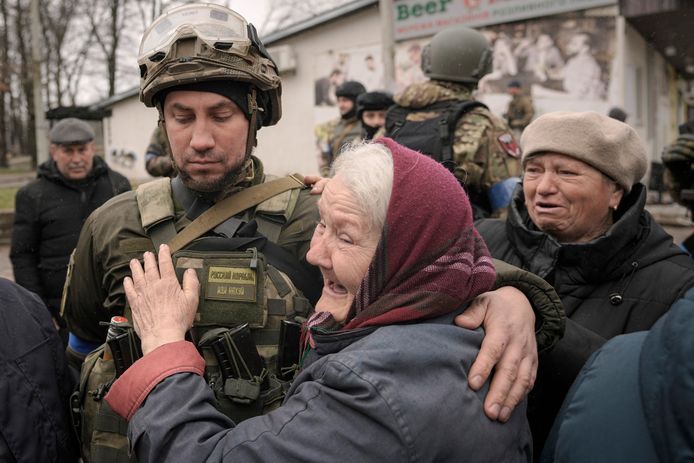 Een oude vrouw bedankt een Oekraïense soldaat in Boetsja.