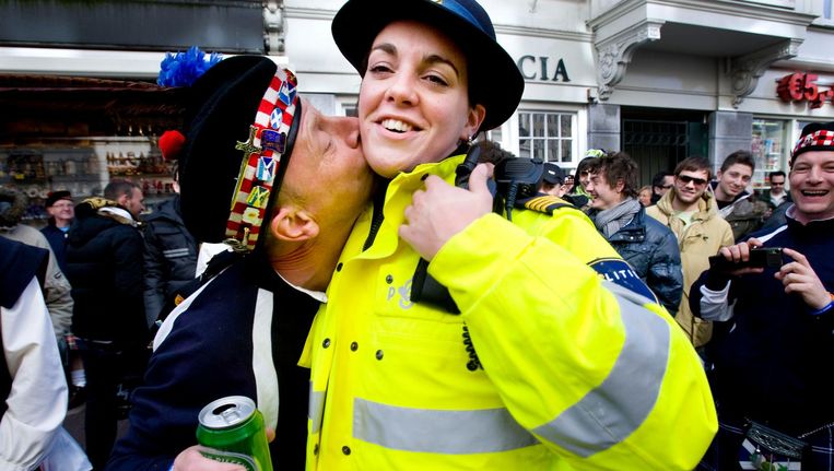 Een Schotse supporter verrast een politieagente met een kus. Beeld anp