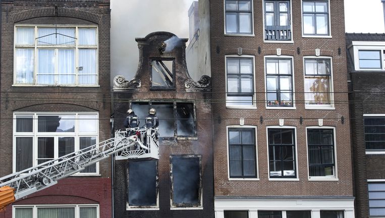 Brandweerlieden bij het uitgebrande pand in Amsterdam. Beeld ANP