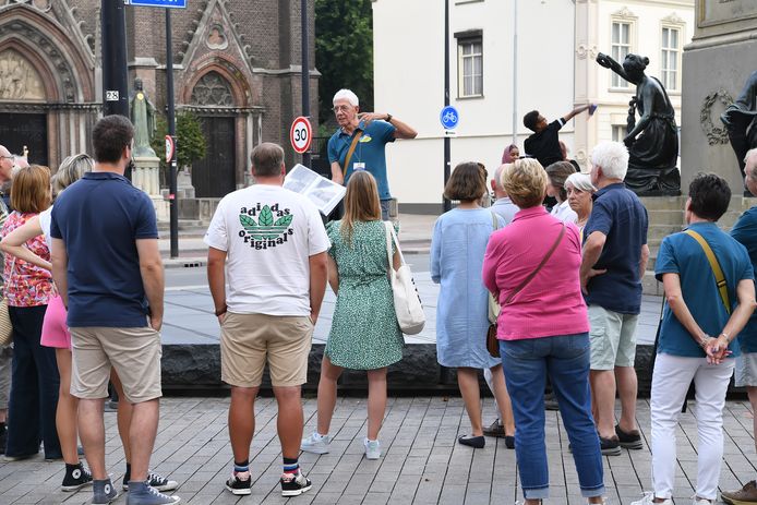 Stadsgids Piet Giesbers in actie met zijn clubje mensen in het centrum van Tilburg, bij het standbeeld van Willem II op de Heuvel.
